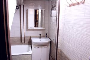 a white bathroom with a sink and a shower at Bozui Hostel Osh in Osh