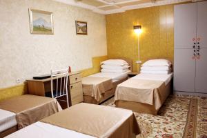 a hospital room with four beds and a desk at Bozui Hostel Osh in Osh