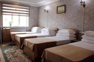 a room with four beds and a window at Bozui Hostel Osh in Osh +5 photos