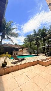 a swimming pool in a yard with palm trees at Recanto da Mari in Paraty