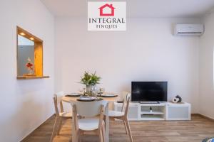 a dining room with a table and a tv at Apartament Marea Baixa in Palamós