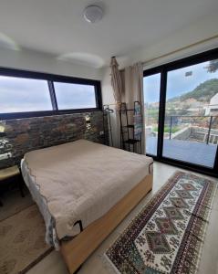 a bedroom with a bed and a large window at La Mer Villa - Entire Cottage in Plomari