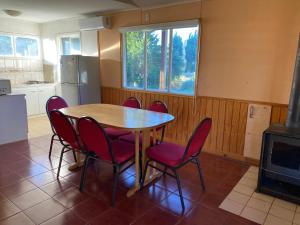 a dining room with a table and chairs and a stove at Patagonia Bordelago Lodge in Puerto Ingeniero Ibáñez