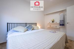 a bedroom with a large bed with white sheets at Apartament Marea Baixa in Palamós +15 photos
