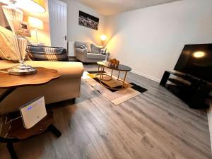 a living room with a couch and a table at Modern 1-Bed Flat Near Northampton General Hopital Town Centre & M1 in Spinney Hill