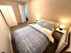 a bedroom with a bed and two night stands at Modern 1-Bed Flat Near Northampton General Hopital Town Centre & M1 in Spinney Hill