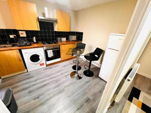 a kitchen with a washer and dryer at Modern 1-Bed Flat Near Northampton General Hopital Town Centre & M1 in Spinney Hill