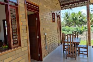 a dining room with a table and chairs on a porch at Bella Casa Bougainville - APA Barra de Mamanguape in Rio Tinto