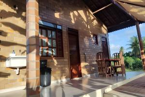 a patio of a house with two chairs on it at Bella Casa Bougainville - APA Barra de Mamanguape in Rio Tinto +44 photos