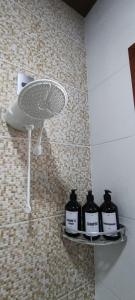a group of four bottles on shelves in a bathroom at Bella Casa Bougainville - APA Barra de Mamanguape in Rio Tinto