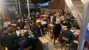 a group of people sitting at tables eating food at Km 0 home Du Già in Muong Cha