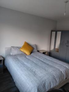 a bedroom with a bed with a yellow pillow on it at GiGi's Bungalow in Galway