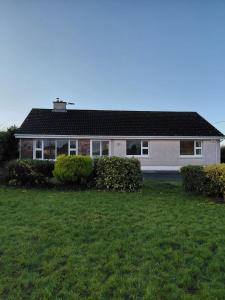 a house with a green lawn in front of it at GiGi's Bungalow in Galway