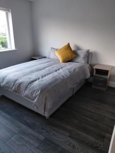 a bedroom with a large bed with a yellow pillow at GiGi's Bungalow in Galway +6 photos