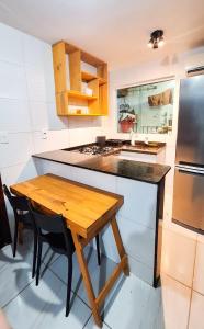 a kitchen with a wooden table and a refrigerator at Duplex Apartamento em Casa Caiada in Olinda