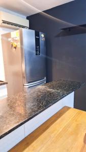 a kitchen with a granite counter top with a refrigerator at Duplex Apartamento em Casa Caiada in Olinda +6 photos