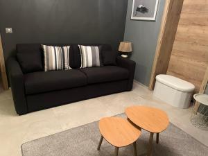 a living room with a black couch and two tables at Schlof'zheim in Friesenheim +29 photos