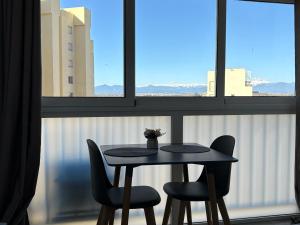a table and two chairs in front of a window at Sweet Dreams Apartment, estilo y confort en 1ª línea, Renovado, Práctico y Anfitrión 5 Estrellas" in Empuriabrava