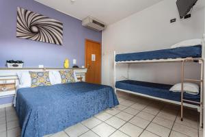 a bedroom with two bunk beds and a blue wall at Hotel Solaris in Gatteo a Mare