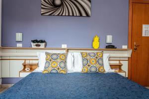 a blue bedroom with a bed with pillows at Hotel Solaris in Gatteo a Mare