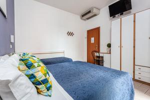 a bedroom with a blue bed and a television at Hotel Solaris in Gatteo a Mare