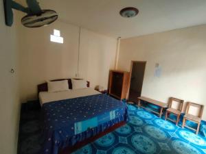 a bedroom with a bed and a blue carpet at Sivilay Guesthouse in Vang Vieng
