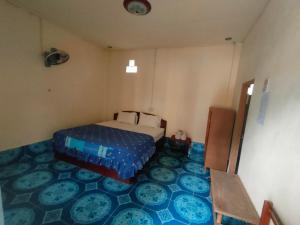 a bedroom with a bed and a blue floor at Sivilay Guesthouse in Vang Vieng +6 photos