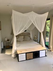 a bedroom with a bed with a canopy at Au Passe-Temps in Mettray