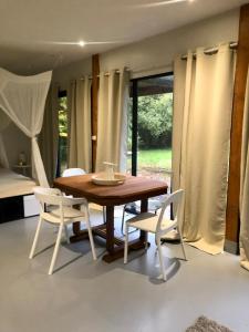 a dining room with a wooden table and white chairs at Au Passe-Temps in Mettray