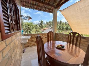 a wooden table with a bowl of fruit on a balcony at Bella Casa Ipê 1º andar APA Barra de Mamanguape in Rio Tinto