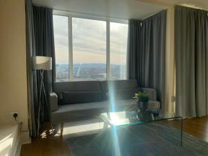 a living room with a couch and a glass table at Newcastle City Penthouse in Newcastle upon Tyne