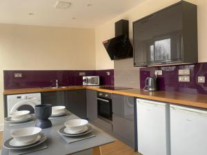 a kitchen with a counter with bowls and plates on it at Newcastle City Penthouse in Newcastle upon Tyne