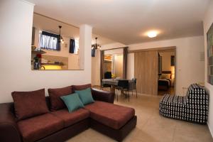 a living room with a brown couch and a dining room at Central Beach Retreat in Trogir