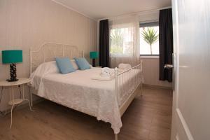 a bedroom with a white bed with blue pillows and a window at Central Beach Retreat in Trogir +32 photos
