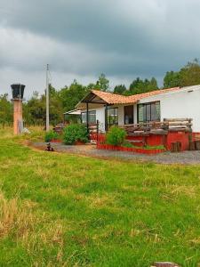 a house in a field with a grass yard at Finca La Milagrosa in Cómbita