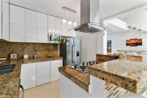 a kitchen with white cabinets and granite counter tops at Casa Lula 5-BR Getaway in Riviera Maya in Playa del Carmen
