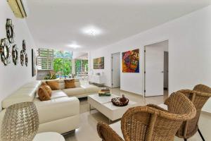 a living room with a white couch and chairs at Casa Lula 5-BR Getaway in Riviera Maya in Playa del Carmen