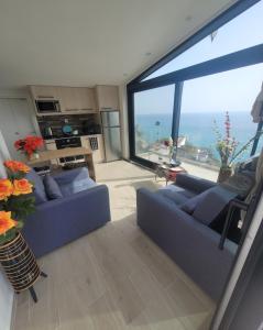 a living room with two blue couches and a large window at La Mer Villa - Entire Cottage in Plomari