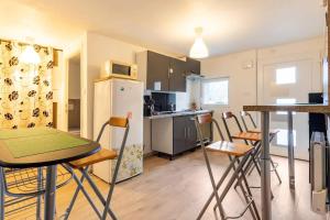 a kitchen with a table and chairs and a refrigerator at Appartement "L'orée des trois frontières" in Allondrelle-la-Malmaison