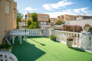 a small balcony with a table and a white fence at Bungalow and private XXL Terrace in Alicante