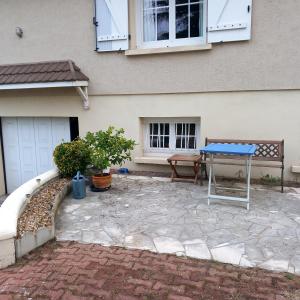 a patio with a blue table in front of a house at Vive le vert pomme ! in Saint-Romain-sur-Vienne