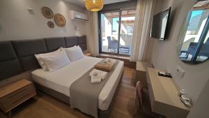 a hotel room with a bed and a television at Tago Houses in Elafonisos