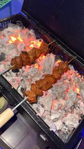 a grill with meat and other foods on it at Golden Kudle Beach Resort in Gokarna