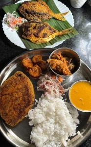 a plate of food with rice and meat and vegetables at Golden Kudle Beach Resort in Gokarna