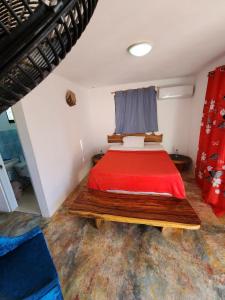 a bedroom with a red bed in a room at Villa KIKI Ensenada in Punta Rucia