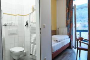 a bathroom with a toilet and a bed in a room at Hotel Kronprinz in Bad Salzdetfurth
