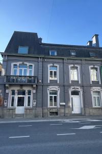 a large gray building on the side of a street at Loft by GIORGI - Centre de Bastogne in Bastogne