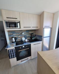 a small kitchen with a stove and a refrigerator at La Mer Villa - Entire Cottage in Plomari +53 photos