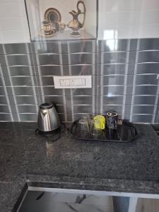 a kitchen counter with a tray with cups on it at Lotus Villa Hampi in Hospet