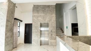 a lobby with a stainless steel elevator in a building at Hotel Harvest Retalhuleu in Santa Cruz Muluá +35 photos